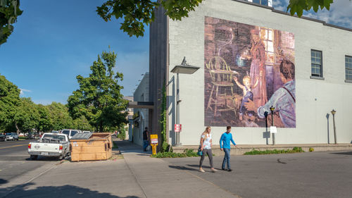 People on street against buildings in city