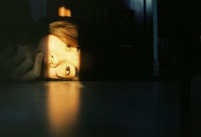 Sunlight falling on young woman lying on floor