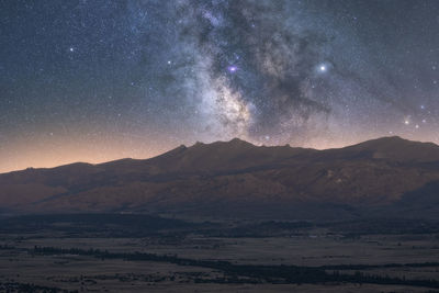 Scenic view of mountains against sky at night