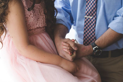 Close-up of man resting hand on woman's lap