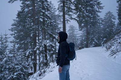 Rear view of man walking on snow covered landscape