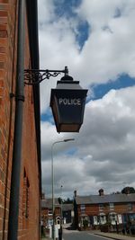 Low angle view of road sign against sky in city