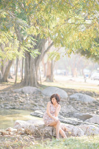 Portrait of woman sitting on tree