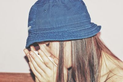 Close-up of woman wearing bucket hat having drink