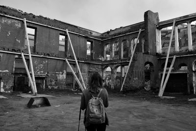 Rear view of woman standing in front of building