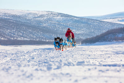 People riding motorcycle on snow covered mountain