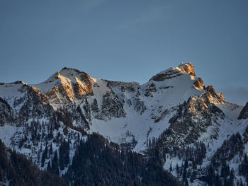 Low angle view of snowcapped mountains against sky