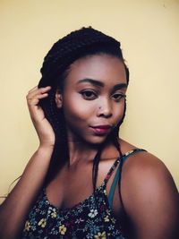 Close-up of young woman standing against gray background