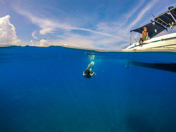 Man swimming in sea against sky