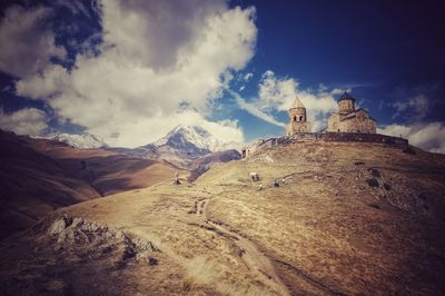 Low angle view of built structure against mountain and sky