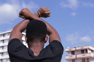 Rear view of man on building against sky