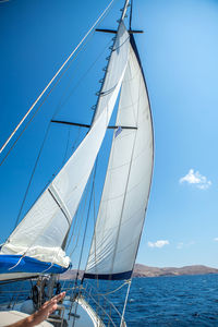 Sailboat sailing in sea against blue sky