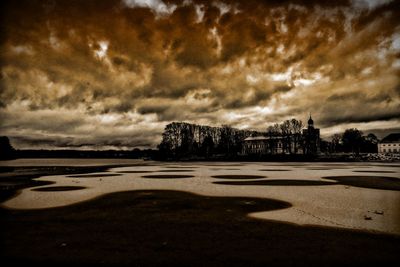 Scenic view of beach against dramatic sky