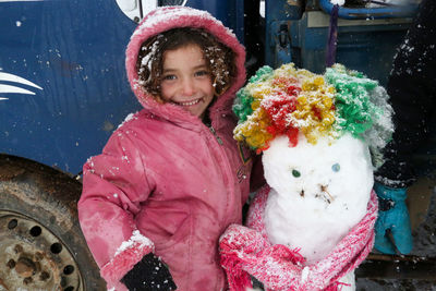 A syrian refugee child at the door of his snow covered tent.