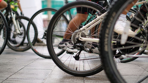 Low section of people riding bicycles on footpath in city