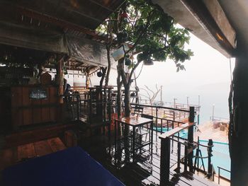 Chairs and tables in restaurant by sea against sky