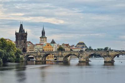 Arch bridge over river against buildings