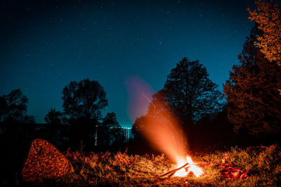 Low angle view of illuminated fire against sky at night