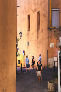 People walking on street against building