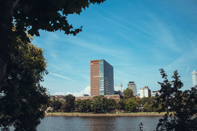 River by buildings against blue sky