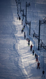 High angle view of people with ski walking on snowcapped mountain