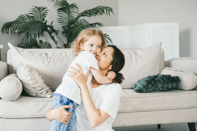 Mother and daughter on bed at home