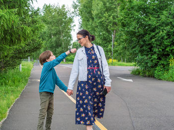 Mom and son walk in the park and talk very lively. summer shooting.