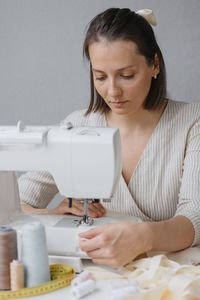 Portrait of woman using sewing machine