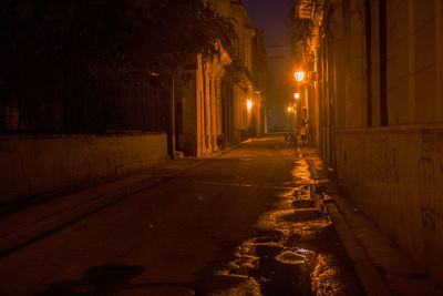Road amidst illuminated city at night