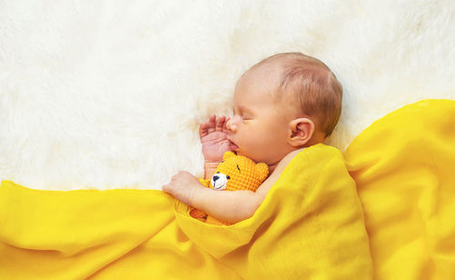 Cute baby girl sleeping on bed at home