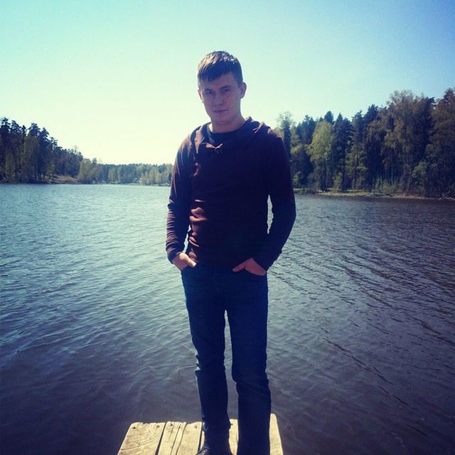 young adult, looking at camera, person, portrait, casual clothing, lifestyles, front view, standing, water, young men, leisure activity, clear sky, sunglasses, smiling, three quarter length, full length, lake, happiness