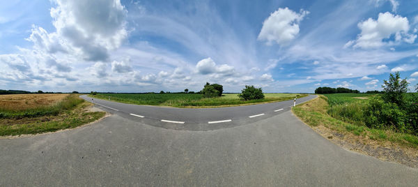 Beautiful high resolution panorama of a northern european country road with fields and green grass.