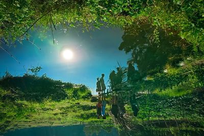 People standing amidst trees in forest against sky