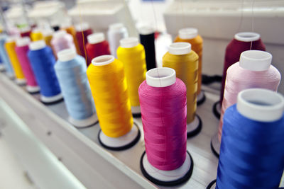 Close-up of colorful thread pools on stand