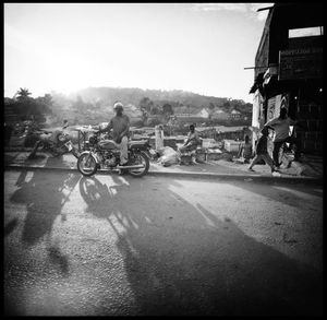 People riding bicycle on road against clear sky