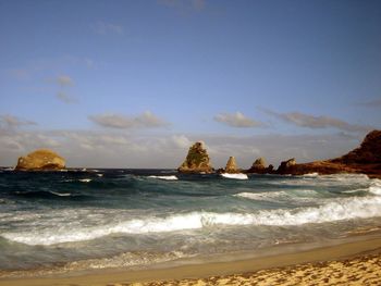 View of calm beach against blue sky