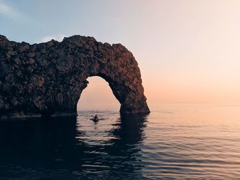 Scenic view of rock formation in sea against sky