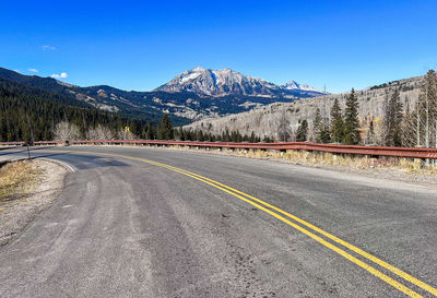 Road by snowcapped mountains against sky