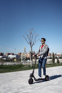 Full length portrait of man against blue sky