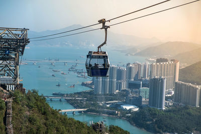 Overhead cable car over sea and buildings