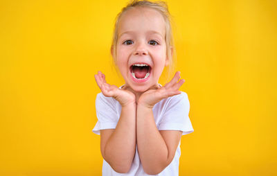 Portrait of cute girl against yellow background