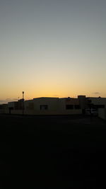 Silhouette building against clear sky during sunset