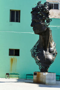 Statue against building in city