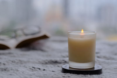 Flame burning at aroma candle for relaxing when reading book in winter season. zen and relax.