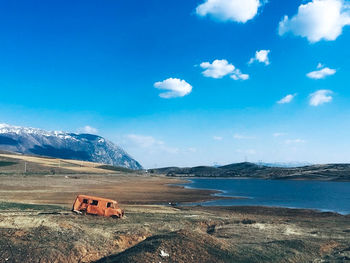 Scenic view of sea and mountains against blue sky