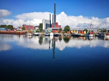 Buildings by river against sky