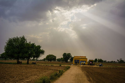Road amidst field against sky
