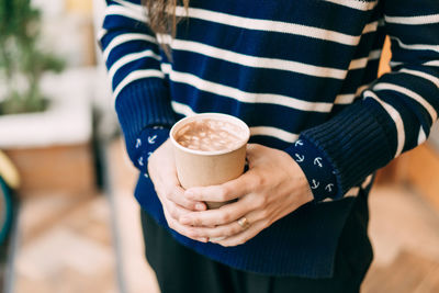 Closeup girl holding a mug with cocoa and marshmallows. 