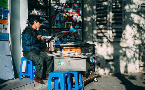 Man sitting on stool at shop