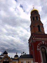 Low angle view of clock tower against cloudy sky